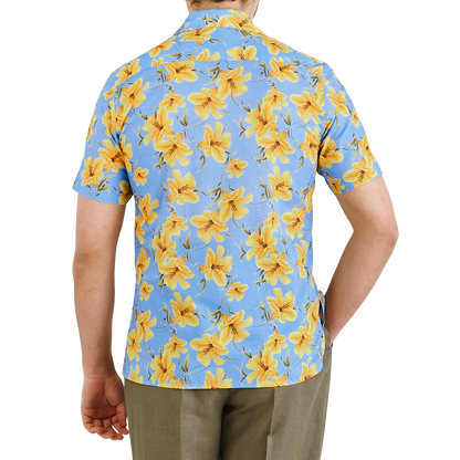 A person wearing an Altea Light Blue Printed Cotton Short Sleeve Shirt with a yellow flower print and khaki pants is shown from the back.