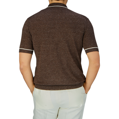 Man standing with his back to the camera wearing an Altea Brown Melange Linen Cashmere Blend Polo Shirt made in Italy and white pants.