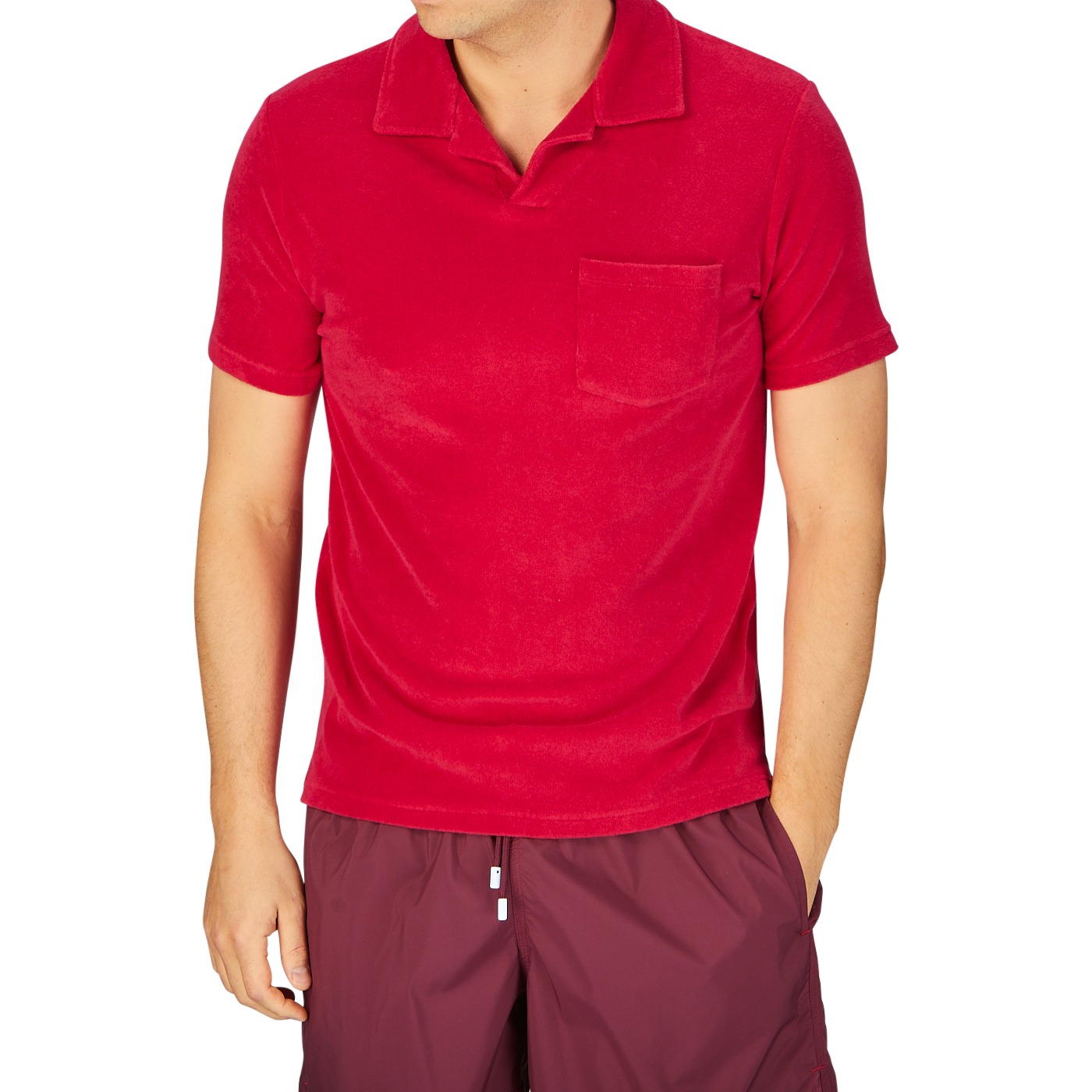 Man in an Altea coral red cotton towelling Capri collar polo shirt and dark shorts.