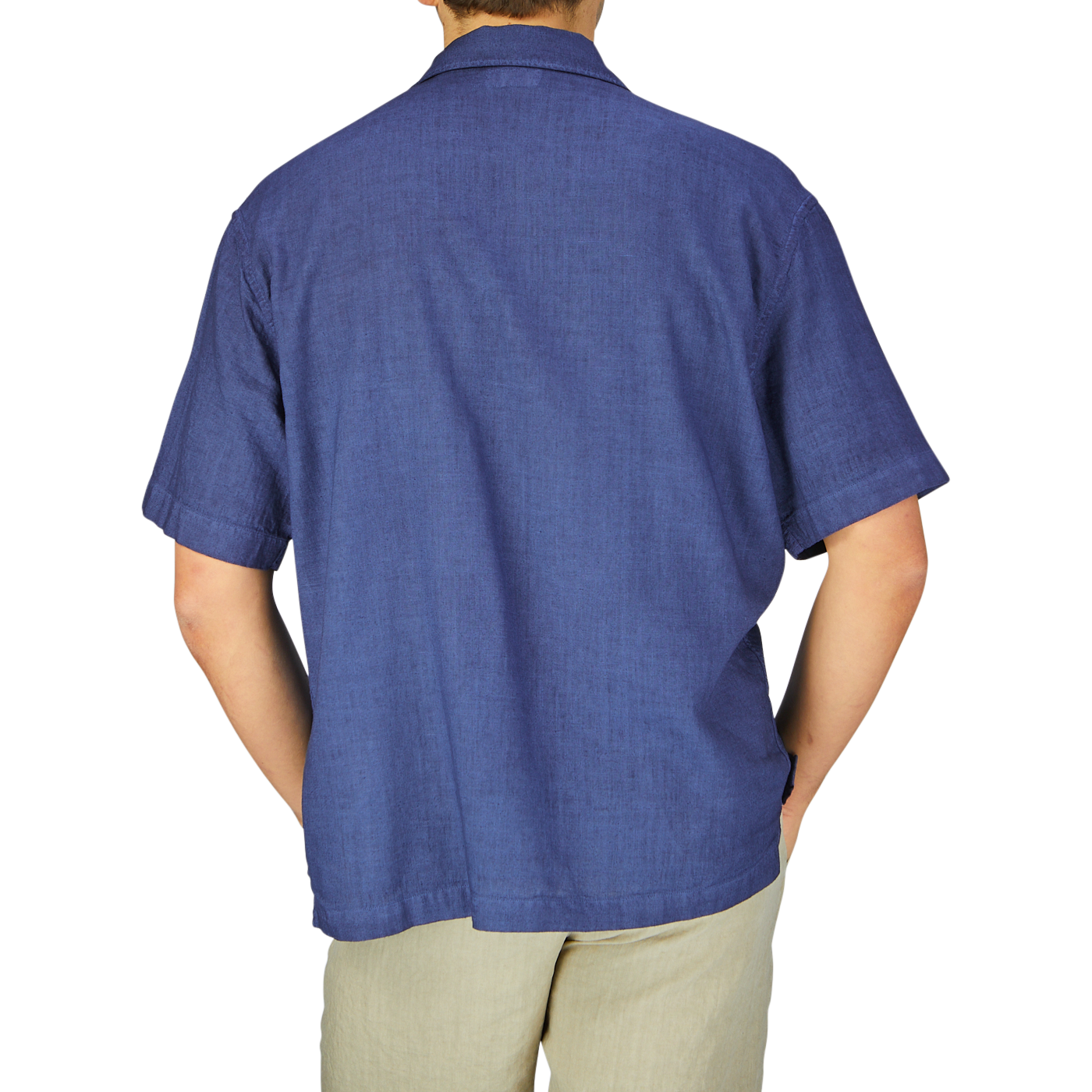 A rear view of a man wearing an Altea dark blue linen blend open collar shirt and beige trousers, showcasing a summer essential look.