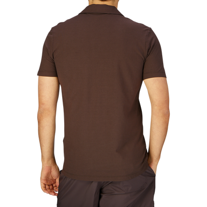 Rear view of a person wearing a Altea Dark Brown Cotton Jersey Capri Collar Polo Shirt and dark pants.