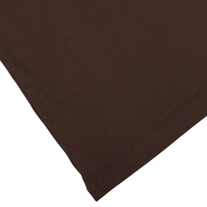 A close-up of a folded dark brown, pure cotton Altea Capri Collar Polo Shirt with visible stitching on a white surface.