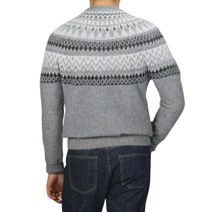 A person wearing an Altea Grey Melange Norwegian Wool Alpaca Crewneck sweater paired with dark blue jeans, seen from the back.