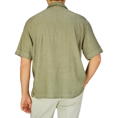 A man viewed from behind wearing an Altea Moss Green Linen Blend Camp Collar shirt and light-colored pants.