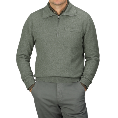 An individual dressed in the Altea Moss Green Wool Fleece 1/4 Zip Sweater and matching pants stands with their hands in pockets.