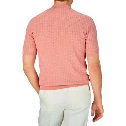 A man standing with his back to the camera wearing a Muted Pink Cotton Capri Collar Polo Shirt by Altea and white pants.