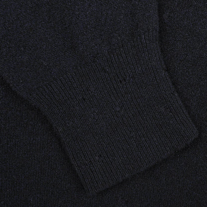 A close-up of a black knitted fabric with a ribbed cuff, part of the Navy Blue Wool Fleece 1/4 Zip Sweater by Altea.