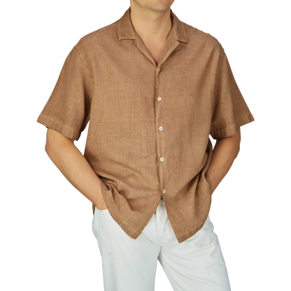 Man wearing an Altea Tobacco Brown Linen Blend Camp Collar Shirt with mother-of-pearl buttons and white pants, cropped at chest height.
