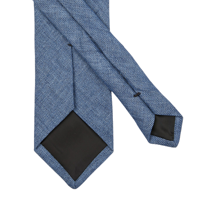An Amanda Christensen Denim Blue Melange Linen Lined Tie on a white background.