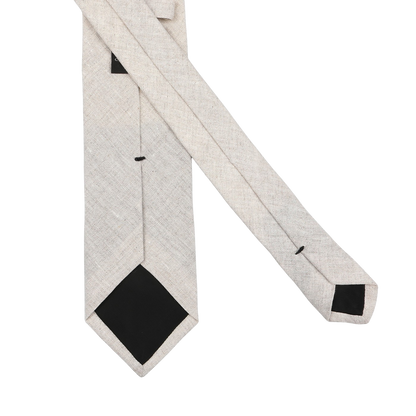 The Amanda Christensen Light Beige Melange Linen Tie, with black pointed ends, is crafted from pure linen and made in Italy, displayed against a light gray background.