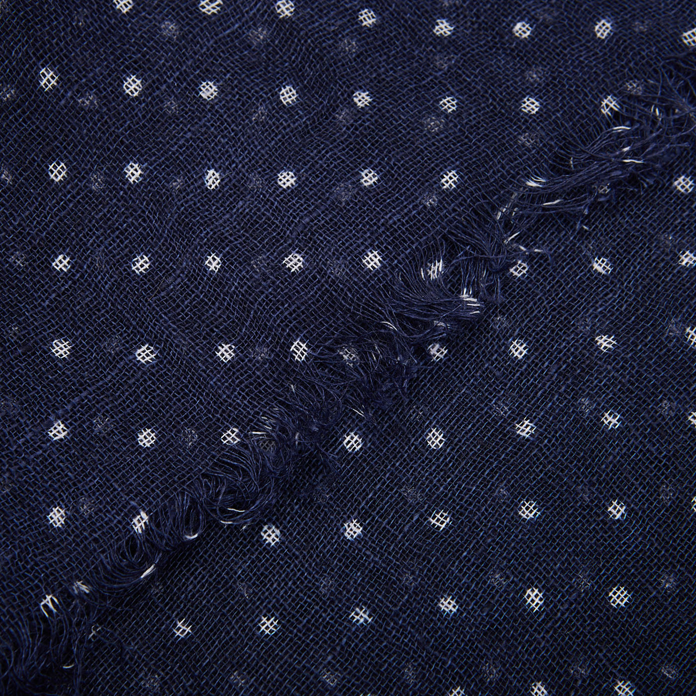 Close-up of a frayed edge on an Amanda Christensen Navy Blue White Dot Linen Gauze Scarf.