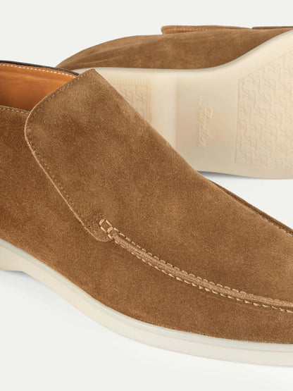 Close-up of Aurélien’s Beige Softey Suede City Loafer slip-ons, featuring cream rubber soles, visible stitching on the upper and toe, subtle sole branding, and a minimalist yet elegant smart-luxury design. , available at Richard Gelding Mayfair