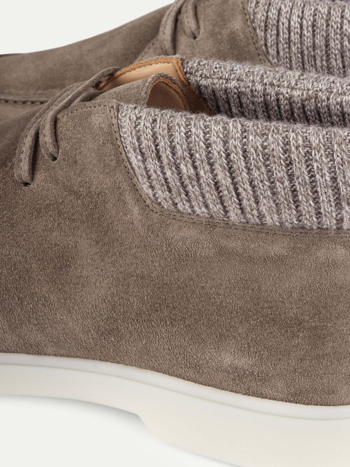 Close-up of Aurélien Ash Grey Suede Desert Boots with Cashwool Trim, showcasing light gray ribbed knit ankle cuffs, white rubber soles, and a brown leather inner lining. The image focuses on the side and top views of the boots, emphasizing their luxurious texture and exceptional Italian craftsmanship against a plain off-white background. , available at Richard Gelding Mayfair