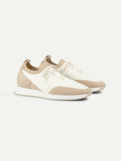 A pair of Aurélien Light Beige Active Knit Wool Sneakers with knit uppers, beige toe, heel, and sole accents, white laces, and heel pull tabs are displayed side by side on a plain white background. , available at Richard Gelding Mayfair