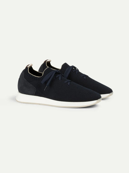 The Aurélien Navy Active Knit Wool Sneakers feature navy knit uppers, white soles, black laces, and a heel pull tab. Their sleek, minimalist design offers lightweight comfort—ideal for everyday wear or light exercise. , available at Richard Gelding Mayfair