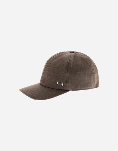 A beige Herno cap, named the Loro Piana Linen Wool Woven Cap, features a curved brim, structured crown, textured linen-wool weave, and a small engraved metal tag above the brim. The background is plain white. , available at Richard Gelding Mayfair