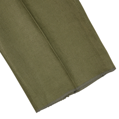 Olive green linen fabric with a clean-cut edge and frayed corner against a white background.