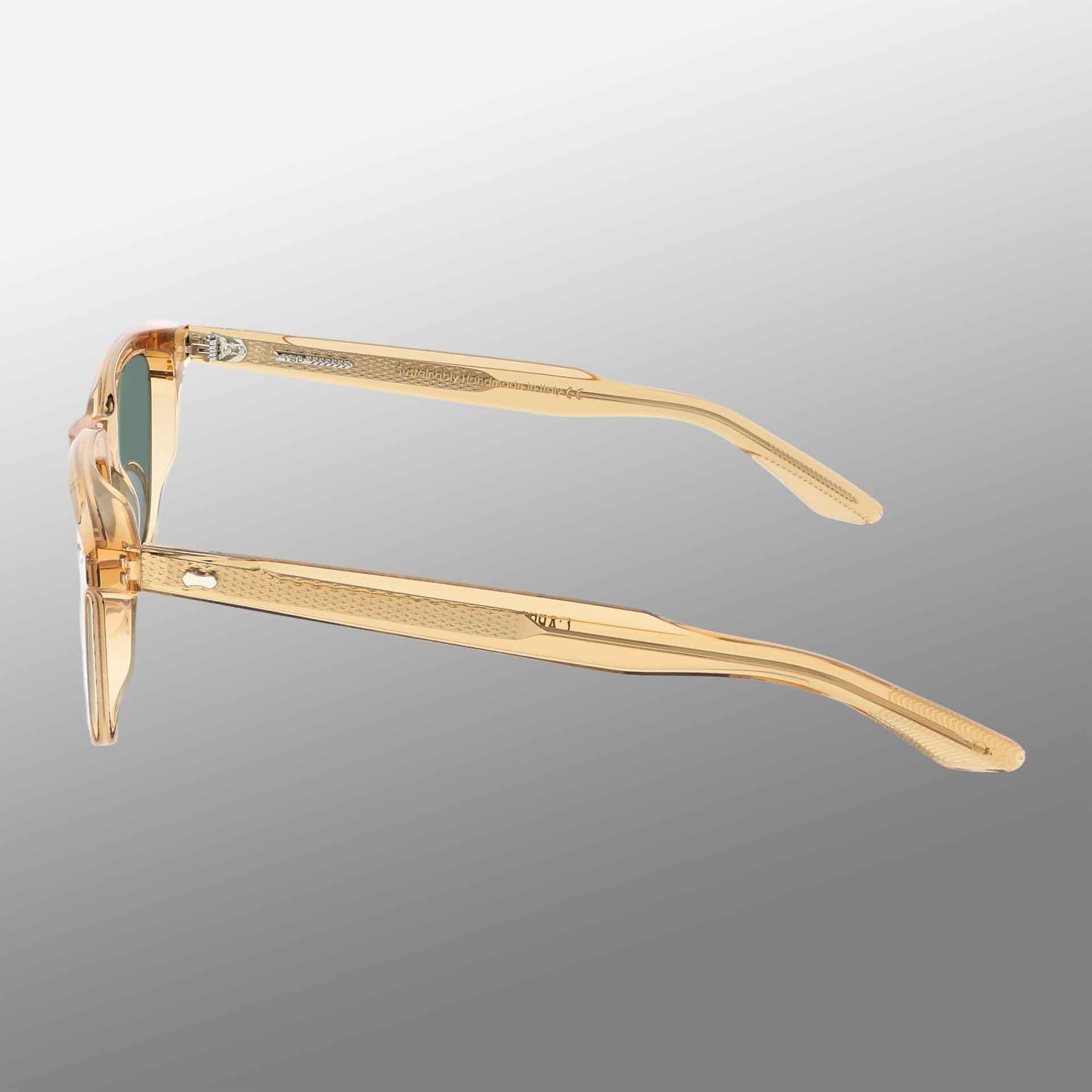 The Carré Eco Champagne | Bottle Green by TBD Eyewear is a pair of transparent, light beige eyeglasses with subtly textured temples, visible hinge area, and slightly yellow-tinted lenses shown from the side on a gray gradient background. , available at Richard Gelding Mayfair