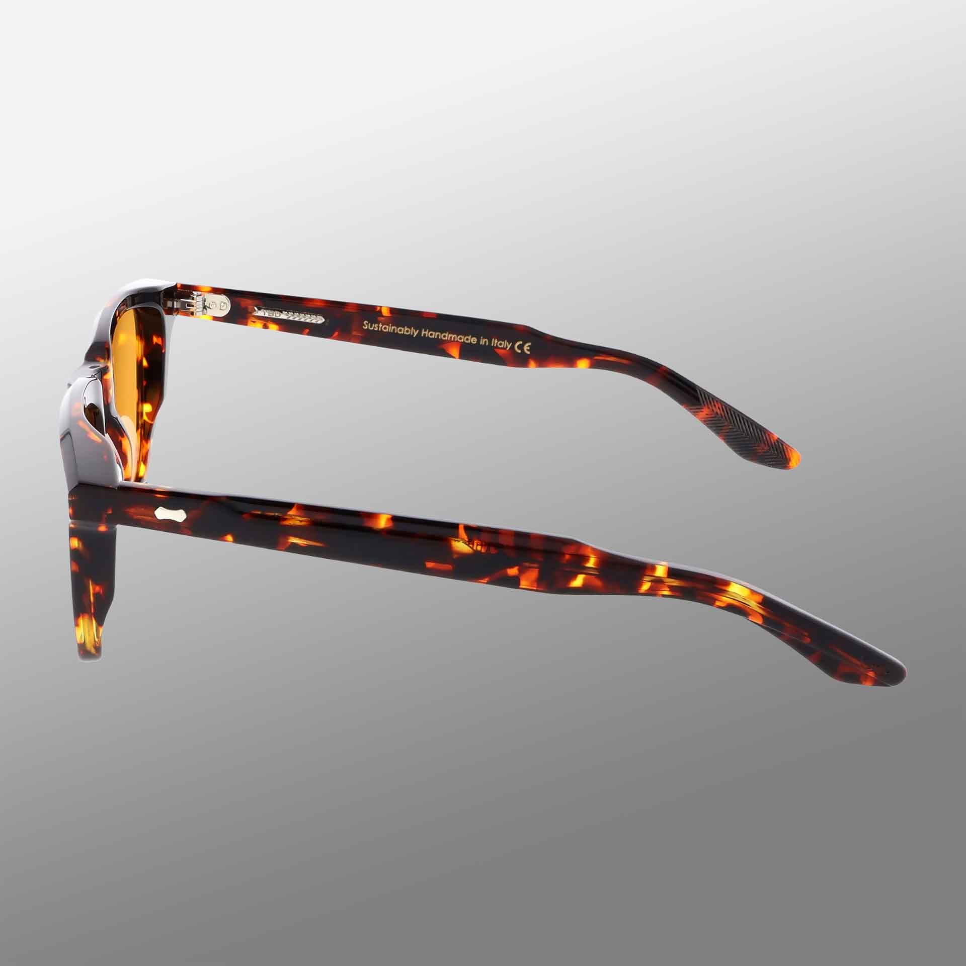 The Carré Eco Dark Havana | Orange eyeglass frames by TBD Eyewear feature a tortoiseshell pattern in orange and brown, shown side and back on a gray gradient. Inside arm text is partially visible, noting they are handmade in Italy. , available at Richard Gelding Mayfair