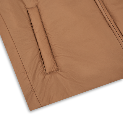 Close-up of the Herno Camel Brown Lightweight Nylon Gilet, featuring a neatly stitched, slanted side pocket and padded matte fabric that highlights its stylish color and texture against a white background. , available at Richard Gelding Mayfair
