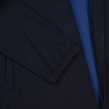 A close-up of the Manto Navy Loro Piana Wool/Silk Rain System Asiago Blouson highlights a folded sleeve, smooth fabric, and visible zipper, with a strip of bright blue fabric beneath the jacket opening. , available at Richard Gelding Mayfair