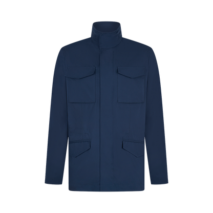 The Manto Navy Japanese Nylon Andromeda Packable Field Jacket features a high collar, front zipper with placket, and four flap pockets, highlighting minimalist Japanese design against a plain white background. , available at Richard Gelding Mayfair