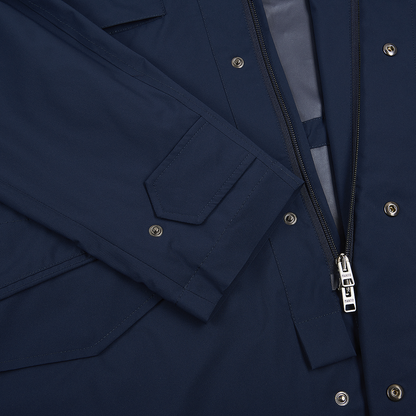Close-up of the Manto Navy Japanese Nylon Andromeda Packable Field Jacket, showing a sleeve with a rectangular flap, silver snap buttons, a partially unzipped zipper, and tailored stitching that highlights Japanese craftsmanship and detailed inner lining. , available at Richard Gelding Mayfair