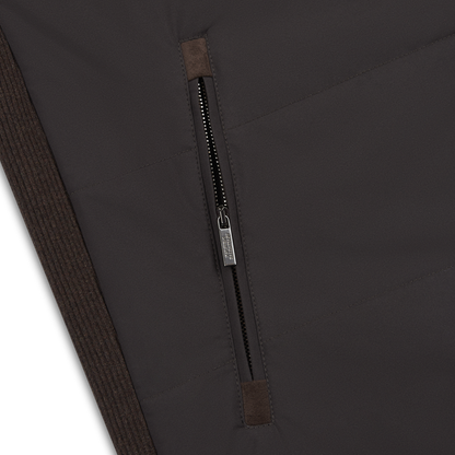 Close-up of the Maurizio Baldassari Chocolate Brown Nylon Gilet, featuring a vertical zippered pocket with metallic pull tab, ribbed details, and precise stitching on this men's weather-resistant sleeveless vest. , available at Richard Gelding Mayfair