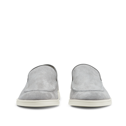 A pair of Cement Grey Suede Leather Debonair Loafers from CQP, with white soles, viewed from the rear.