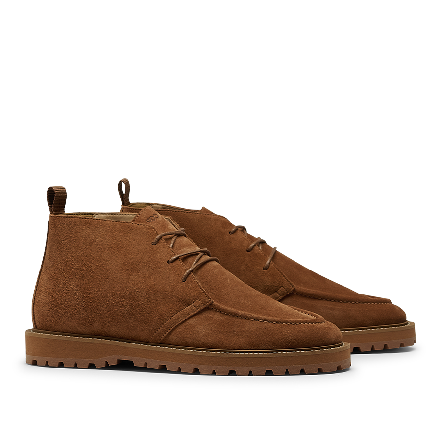 The CQP Snuff Suede Leather Astra Dessert Boots, crafted from brown suede, feature laces and rugged soles that perfectly capture the essence of chukka boots when viewed from the side.