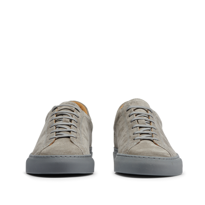Front view of a pair of CQP Granit Grey Suede Leather Racquet Sr sneakers with white laces on a transparent background.