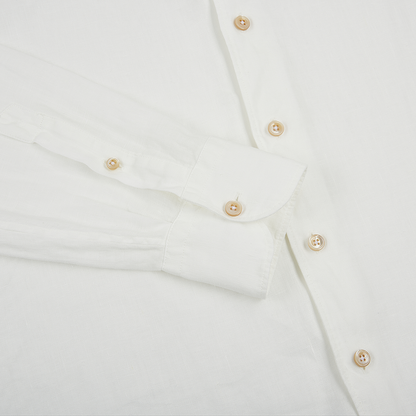 A close-up of the Alessandro Gherardi White Linen Long Sleeve Shirt shows its lightweight, textured fabric, light brown buttons, and single-button cuff on the front and one sleeve. , available at Richard Gelding Mayfair