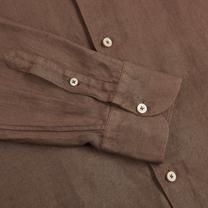 A close-up of the Alessandro Gherardi Tobacco Brown Linen One Piece Collar Casual Shirt shows textured fabric, visible stitching, and two beige buttons on the cuff with another on the placket. , available at Richard Gelding Mayfair
