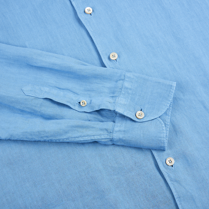 A close-up of the Alessandro Gherardi Mid Blue Linen One Piece Collar Casual Shirt laid flat, showing the buttoned cuff, front with white buttons, and soft textured linen fabric neatly arranged for display. , available at Richard Gelding Mayfair