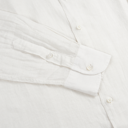 A close-up of the Fedeli Off White Linen Cutaway Collar Shirt laid flat, highlighting the cuff, sleeve, white buttons, and fine stitching. The lightweight, slightly sheer fabric showcases the shirt’s classic refined details. , available at Richard Gelding Mayfair