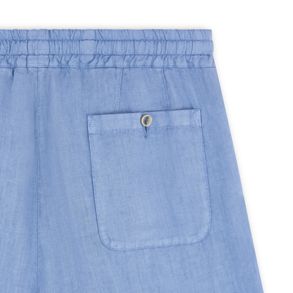 Close-up of Altea’s Sugar Packet Blue Linen Drawstring Trouser featuring a lightweight elastic waistband and a single back pocket with a flap and tan button. Visible stitching details stand out against the white background. , available at Richard Gelding Mayfair