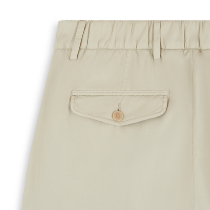 Close-up of Barmas Cream Cotton/Silk Stretch Waistband Chinos, showing the waistband with belt loops, stitched seam, and flap pocket with tan button. The smooth, lightweight fabric is set against a plain white background; only the upper section is visible. , available at Richard Gelding Mayfair