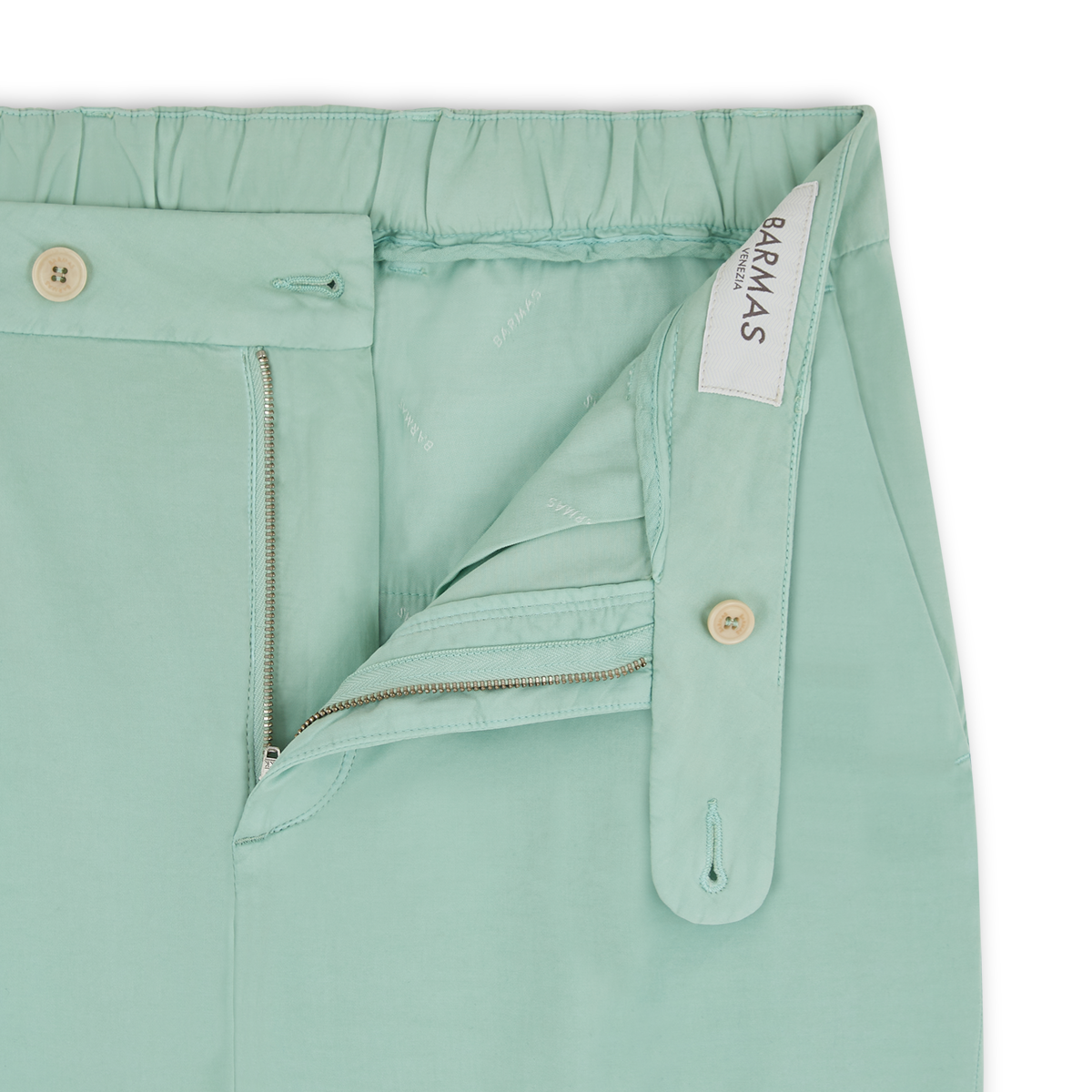 Close-up of Aqua Green Cotton/Silk Stretch Waistband Chinos by Barmas, showing button closure, zipper, inner button tab, and an elasticized back waistband for adjustable fit. Brand label "Barmas" visible inside. , available at Richard Gelding Mayfair