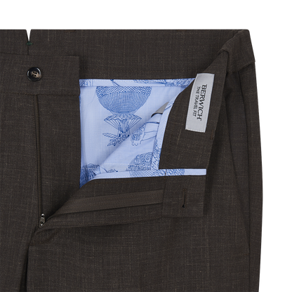 Close-up of the waistband and fly of the Berwich Brown Wool Silk Linen Loro Piana Casual Trouser, partly opened to show light blue pocket lining with intricate sketches and a BERWICH THE FINAL CUT fabric label inside. , available at Richard Gelding Mayfair