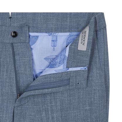 Close-up of the Berwich Azure Blue Wool Silk Linen Loro Piana Casual Trouser, featuring a partially open zipper, buttoned waistband, light blue lining with blue sketches, and a beige BERWICH FANTASTIC FIT label. Fabric has a textured look. , available at Richard Gelding Mayfair