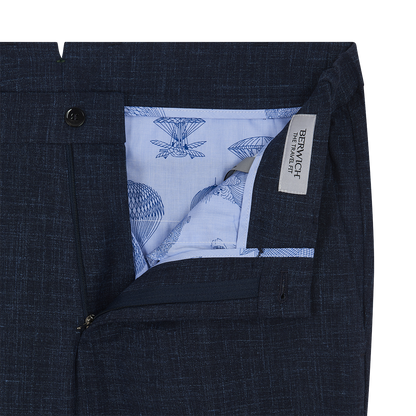 Close-up of Berwich Navy Blue Wool Silk Linen Loro Piana Casual Trouser with open zipper. Light blue hot air balloon and parachute pattern lines the interior. A white tag reads BERWICH THE TRAVEL FIT. , available at Richard Gelding Mayfair