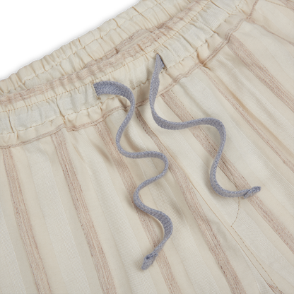 Close-up of Fedeli Cream Striped Linen Drawstring Trousers featuring vertical tan stripes, an elastic waistband, and two wavy light gray drawstrings. The soft, textured linen fabric embodies timeless style with practical comfort. , available at Richard Gelding Mayfair