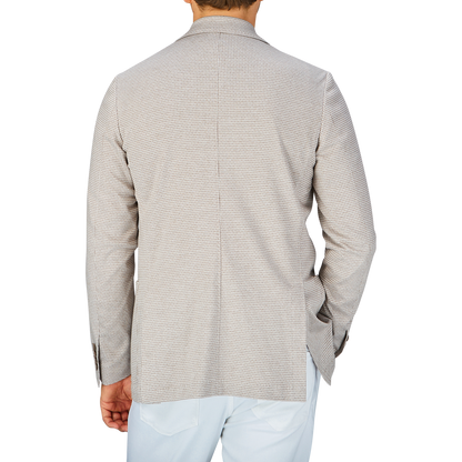 Rear view of a person wearing a Canali Beige Houndstooth Cotton Jersey Blazer with the collar turned up.