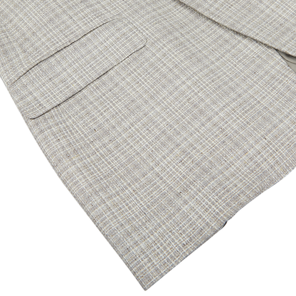 Close-up of a Beige Melange Silk Wool Basketweave Blazer in gray textured fabric, possibly from Canali, displayed on a flat surface.