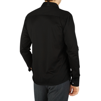 The back view of a contemporary man wearing a black Canali Black Cotton Jersey Casual Shirt.