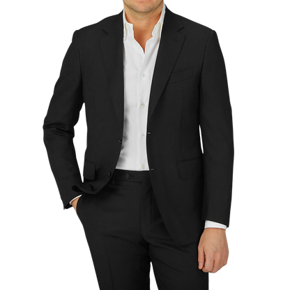 A man wearing a timeless Black Virgin Wool Twill Suit by Canali with structured shoulders and a crisp white shirt.