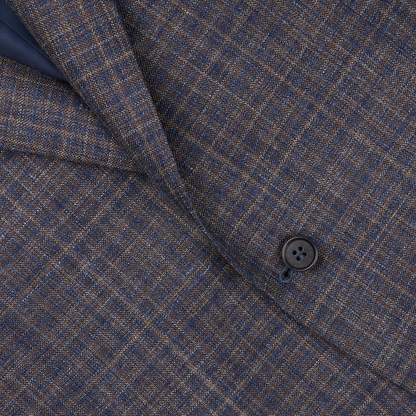 Close-up of a textured blue gingham checked wool silk linen Canali blazer with a visible button, highlighting the detailed weave and pattern.