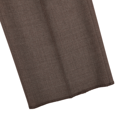 Close-up of Canali's Brown Matte Wool Flat Front Trousers fabric swatch, showcasing its textured, woven look reminiscent of formal trousers, with neatly finished edges.