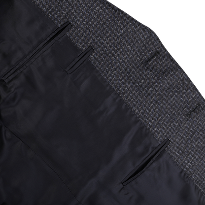 Detailed view of the inner lining of a dark blue checked business suit jacket made from 100% wool. This Canali Drop 6 Blazer showcases a silky black interior and inner pockets, combining elegance with functionality.
