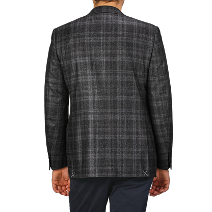 The man is dressed in a Canali Dark Grey Checked Wool Silk Drop 6 Blazer, radiating Milanese style as he stands against a plain background, viewed from the back.